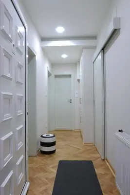 a hallway with a door and a black and white rug at Apartment Zavičaj in Vrnjačka Banja