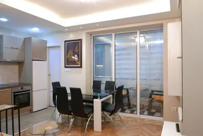 a kitchen and dining room with a table and chairs at Apartment Zavičaj in Vrnjačka Banja