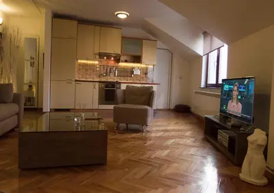a living room with a couch and a tv in it at Apartment Niš Center in Niš