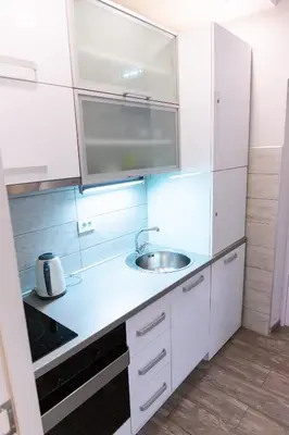 a kitchen with white cabinets and a sink at SPA Apartment Nalis in Niš