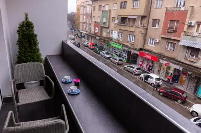 a balcony with two chairs and a view of a street at SPA Apartment Nalis in Niš