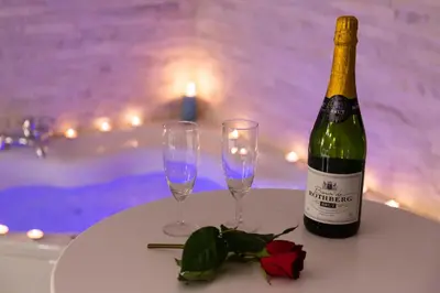 a bottle of wine and two glasses on a table at SPA Apartment Nalis in Niš