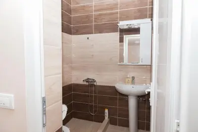 a small bathroom with a sink and a shower at Prenoćište Kovač in Vranje