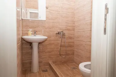a bathroom with a sink and a shower and a toilet at Prenoćište Kovač in Vranje
