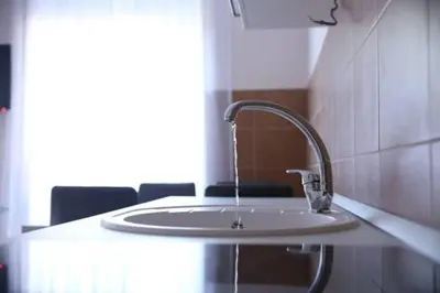 a white sink in a room with chairs at Apartments Lukic in Vrnjačka Banja