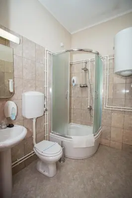 a bathroom with a shower and a toilet and a sink at Sin-Kom Hotel Garni in Pirot