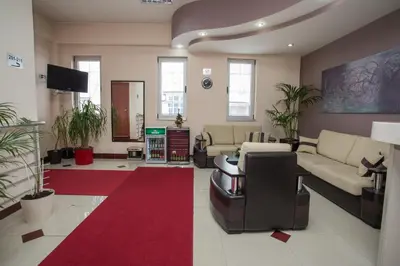 a living room with couches and a red carpet at Sin-Kom Hotel Garni in Pirot
