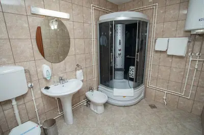 a bathroom with a shower and a toilet and a sink at Sin-Kom Hotel Garni in Pirot