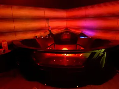 a bath tub in a room with red and pink lights at Ceca Apartman in Niš