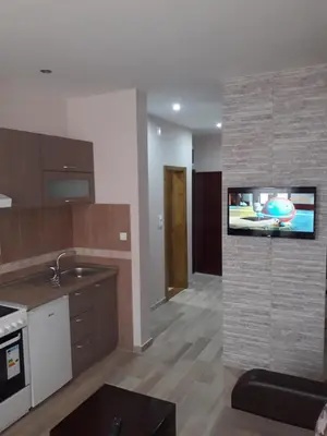 a kitchen with a flat screen tv on a wall at Apartmani Radulović in Vrnjačka Banja