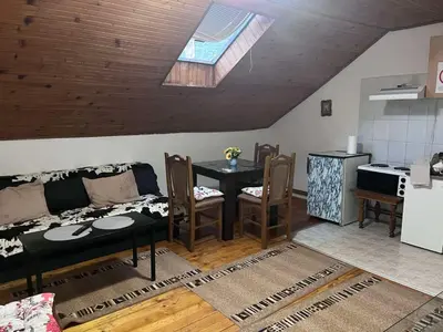 a living room with a table and a kitchen at Vila Lenka Sokobanja in Soko Banja