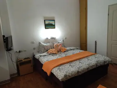 a bedroom with a bed with an orange ribbon on it at Vila Lenka Sokobanja in Soko Banja