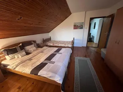 a bedroom with a large bed with a wooden ceiling at Vila Lenka Sokobanja in Soko Banja