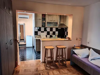 a kitchen with a counter and two bar stools at Apartman Ristic in Niška Banja