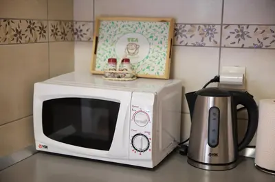 a white microwave sitting on a counter with a coffee pot at Apartman Lena in Vrnjačka Banja