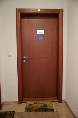 a large wooden door with a sign on it at Apartman Lena in Vrnjačka Banja