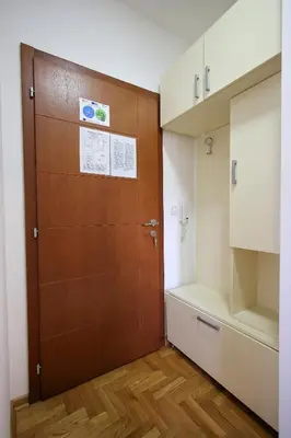 a bathroom with a wooden door and a closet at Apartman Lena in Vrnjačka Banja