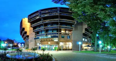 a large building at night with a building at Apartman Lena in Vrnjačka Banja