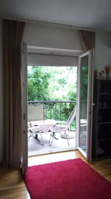an open door to a balcony with a table and a chair at Panorama 5 in Soko Banja