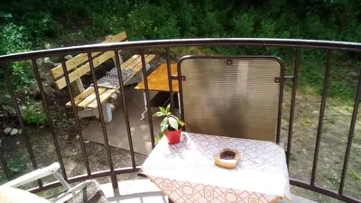 a balcony with a table with a plant on it at Panorama 5 in Soko Banja
