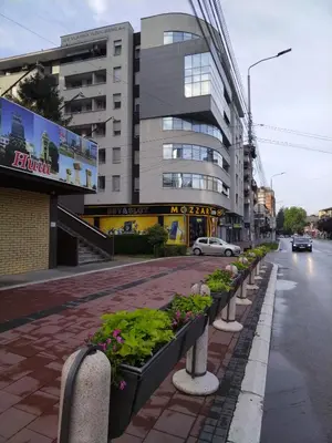 a street with a row of plants on a sidewalk at Naissa Apartment in Niš
