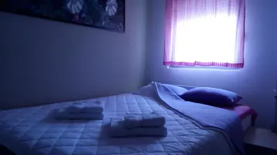 a bedroom with a bed with two pillows and a window at Naissa Apartment in Niš