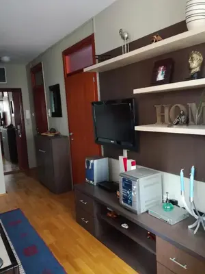 a living room with a desk with a microwave and a tv at Naissa Apartment in Niš