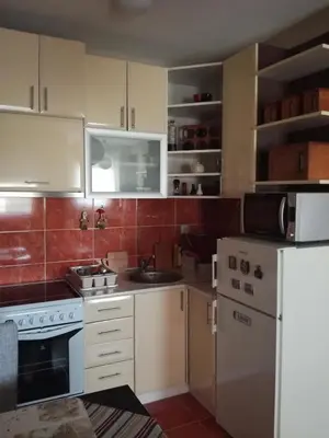 a kitchen with white cabinets and a white refrigerator at Naissa Apartment in Niš