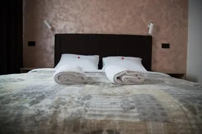 a bedroom with a bed with towels on it at Hotel 