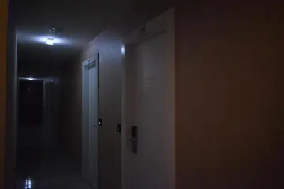an empty hallway with a door in a dark room at Hotel 