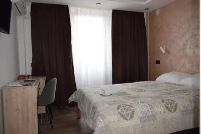 a bedroom with a bed and a desk and a window at Hotel 