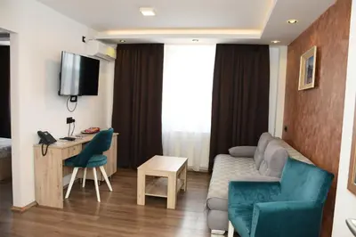 a hotel room with a couch and a table and a desk at Hotel 