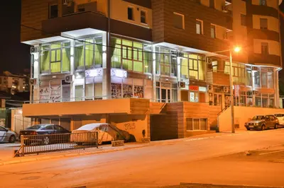 a building with cars parked in front of it at Harmony Bed and Breakfast in Vranje