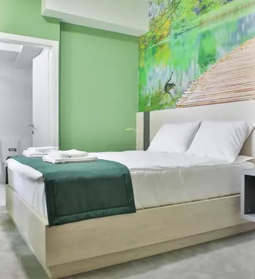 a bedroom with a bed with a painting on the wall at Harmony Bed and Breakfast in Vranje