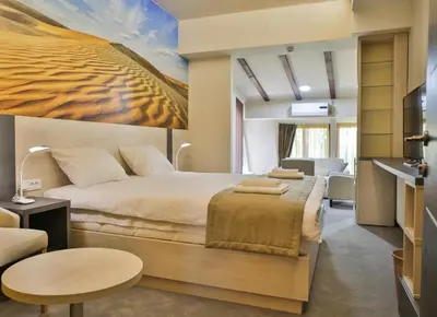 a bedroom with a large bed with a painting on the wall at Harmony Bed and Breakfast in Vranje