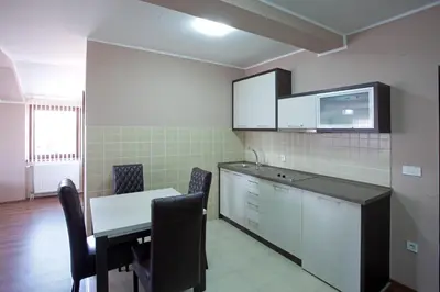 a kitchen with a table and chairs in a room at Guesthouse Vitez in Vranje