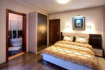 a bedroom with a large bed and a bathroom at Guesthouse Vitez in Vranje