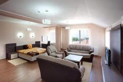 a living room with a bed a couch and chairs at Guesthouse Vitez in Vranje