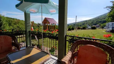 a porch with a table and chairs and an umbrella at Apartment Pavlovic in Soko Banja