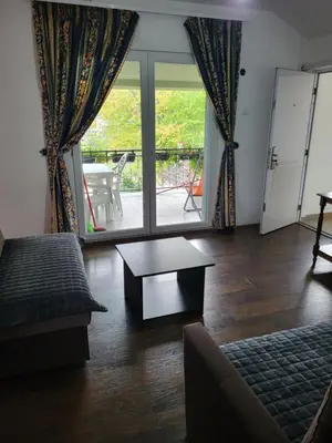 a living room with a couch and a table and a window at Apartment Pavlovic in Soko Banja