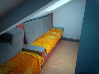 a room with two beds with orange sheets at Studio Pinos in Soko Banja