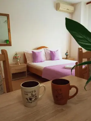 two coffee cups sitting on a table in a bedroom at Apartman Anđelina Vrnjačka Banja in Vrnjačka Banja