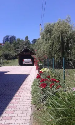 a parking lot with a garage with flowers at Apartman Anđelina Vrnjačka Banja in Vrnjačka Banja