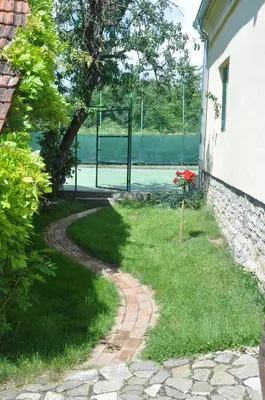 a path leading to a tennis court with a fence at Guesthouse Djurić in Negotin