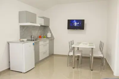 a kitchen with a table and a table and chairs at Apartmani 