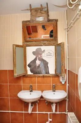 a bathroom with two sinks and a picture of a man at Inn Cakmara in Raška