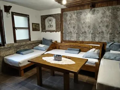 a room with two beds and a table in it at Seosko turističko domacinstvo Imunsan in Niš