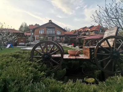 a wooden wagon in front of a house at Seosko turističko domacinstvo Imunsan in Niš