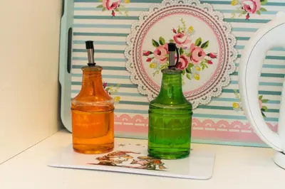 two bottles sitting on a shelf next to a refrigerator at Apartment Aleksija in Niš