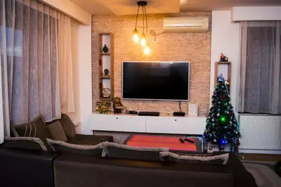 a living room with a christmas tree and a television at Apartment Aleksija in Niš